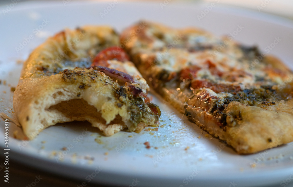 Side view and closeup of vegetarian pesto pizza on white plate. Side view and closeup of vegetarian pesto pizza on white plate.