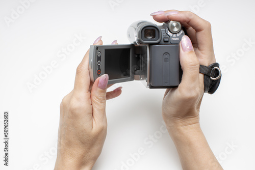 female hand opens the rotary screen of an old video camera photo