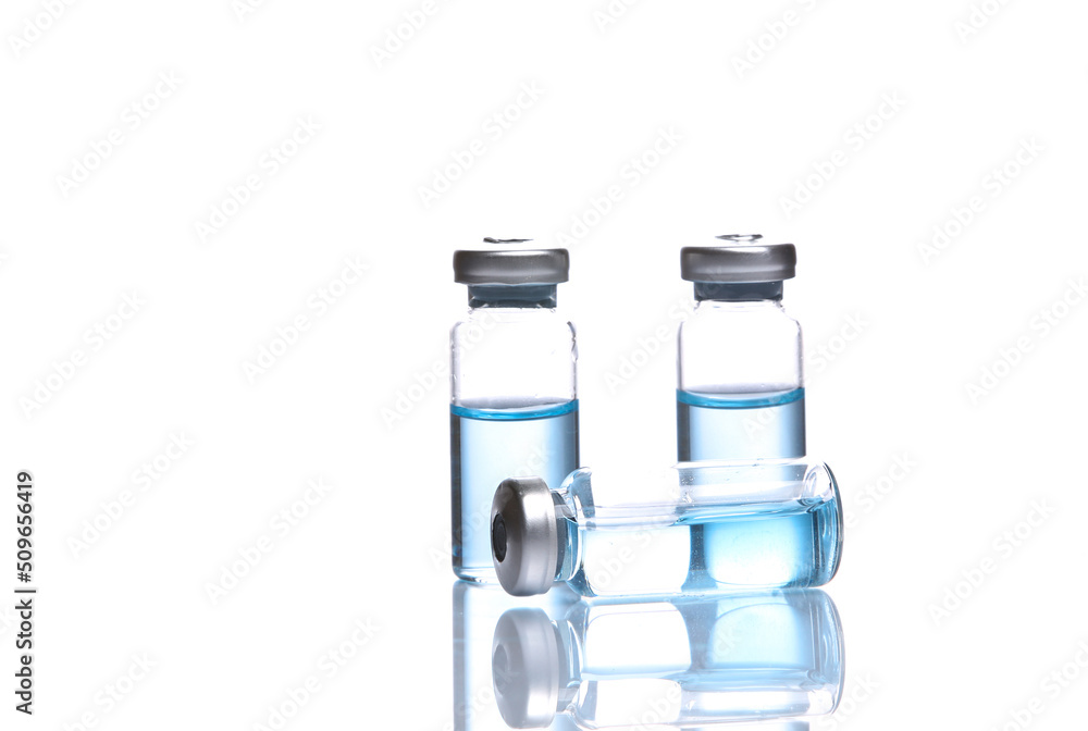 Vaccine bottles with blue liquid isolated on white background with reflection Vaccine bottles with blue liquid isolated on white background with reflection