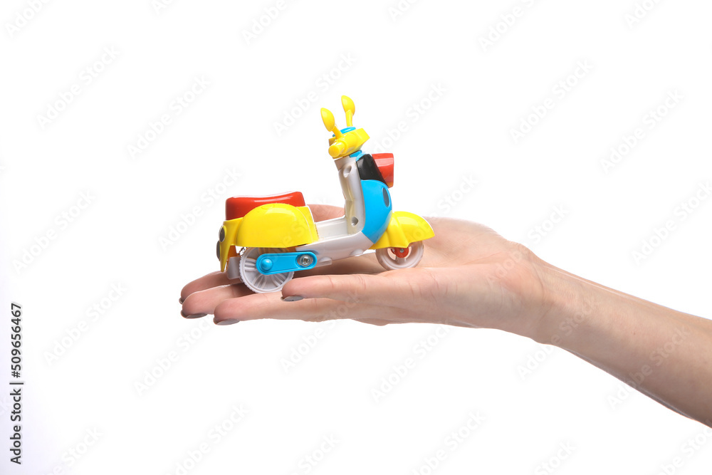 Toy scooter moped on palm of the hand isolated on white background Toy scooter moped on palm of the hand isolated on white background