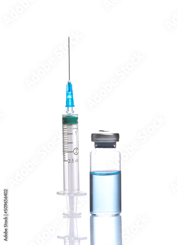 Vaccine bottle with blue liquid and syringe isolated on white background with reflection