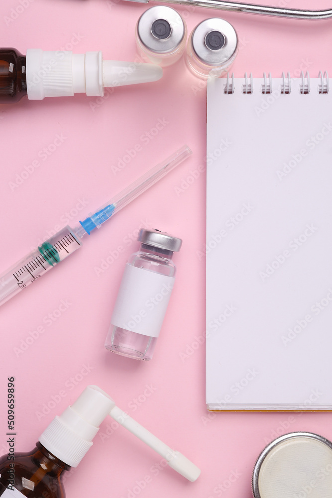 Fototapeta premium Flat lay composition of notebook with medicines on a pink background. Top view