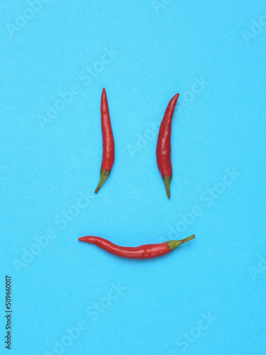 Scary face made of chilli pepper on a blue background