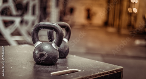Kettlebells on a wooden box in the gym. Blurred background