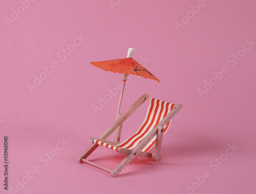 Print op canvas Deck chair with umbrella on a pink background. Beach rest
