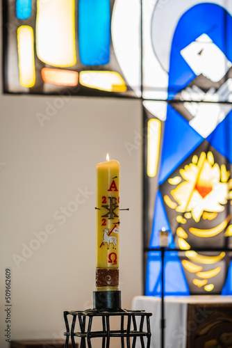 Religious candle and Catholic church stained glass detail