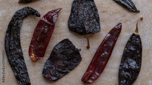 Dried chili peppers: Guajillo, Ancho and Pasilla top view. Table spin. photo