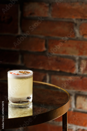 Obraz na płótnie Pisco sour cocktail - whiskey with lime, egg white, sugar syrup in glass on dark background. Space for text w salonie