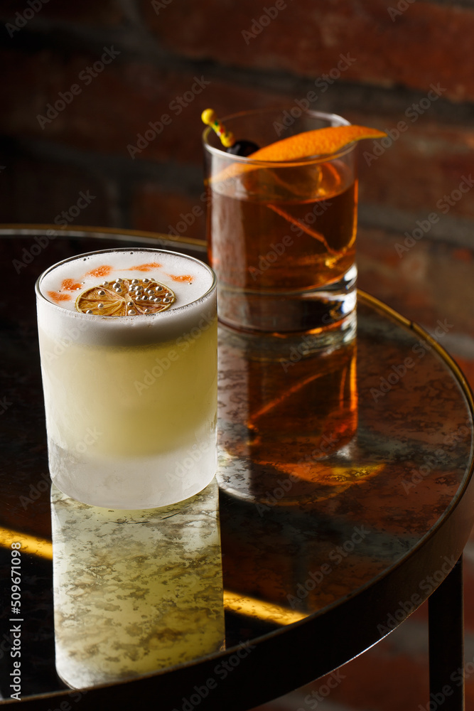 Pisco sour cocktail - whiskey with lime, egg white, sugar syrup in glass on dark background. Space for text