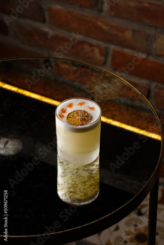 Obraz na płótnie Pisco sour cocktail - whiskey with lime, egg white, sugar syrup in glass on dark background. Space for text w salonie