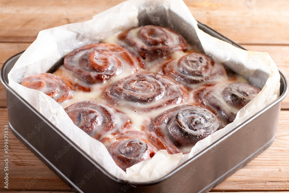 Homemade cinnamon rolls with cream cheese in a baking dish. Seasonal homemade pastry - cinnabons for breakfast or holidays Homemade cinnamon rolls with cream cheese in a baking dish. Seasonal homemade pastry - cinnabons for breakfast or holidays