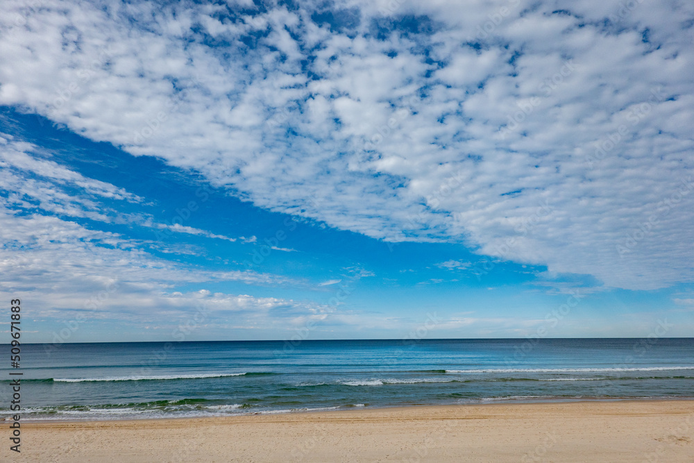 Surfer's Paradise beach to sea and horizon with white soft clouds formation