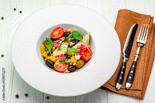 Salad with fish fillet, orange, olives, spinach and shrimps photo