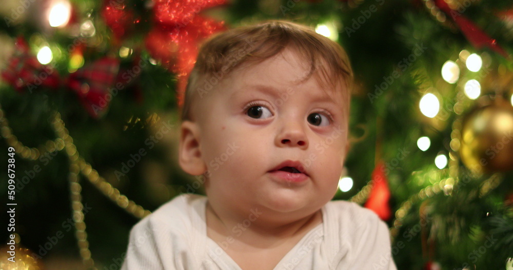 Baby boy face portrait during christmas holiday season. Infant with blinking light in background Baby boy face portrait during christmas holiday season. Infant with blinking light in background