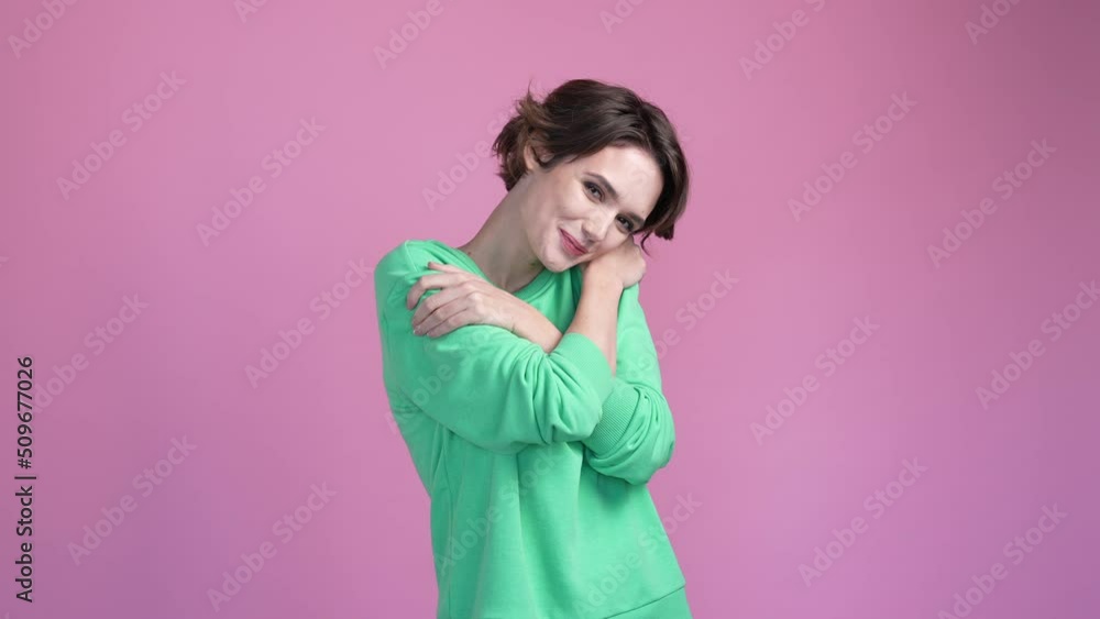 Sweet lady hugging herself isolated pastel color background Sweet lady hugging herself isolated pastel color background