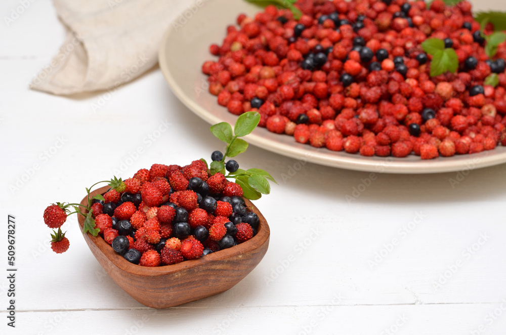 still life with wild berries on the table, strawberries and blueberries in a bowl still life with wild berries on the table, strawberries and blueberries in a bowl