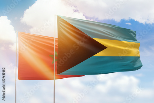 Sunny blue sky and flags of bahamas and morocco