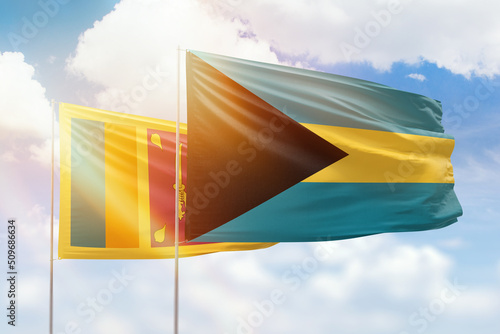 Sunny blue sky and flags of bahamas and sri lanka