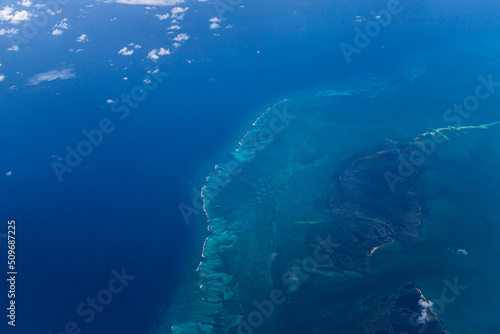 Aerial view of blue ocean and underwater landmarks with a few clouds