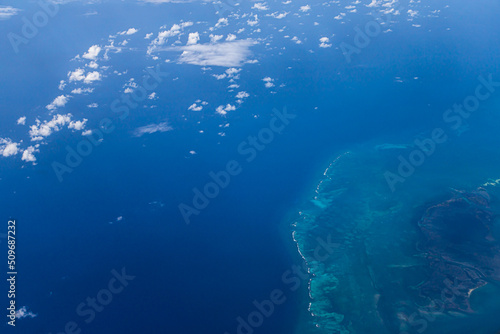 Aerial view of blue ocean and underwater landmarks with a few clouds