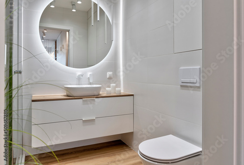 Papier peint Interior of bathroom with ceramic bowl on the wooden cabinet, wooden tile on the floor, round mirror with led lights