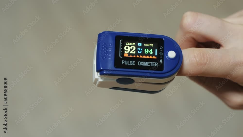 Close-up on a finger in a pulse oximeter. Check the pulse of the oxygen in the blood. Treatment and diagnostics at home, low rates Close-up on a finger in a pulse oximeter. Check the pulse of the oxygen in the blood. Treatment and diagnostics at home, low rates