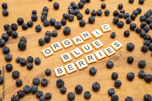 healthy organic blueberries letters on wood background