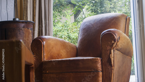 Canapé en cuir dans un salon.
Salon en bois avec un vieux fauteuil brun.
pièce de cuir abimé  photo