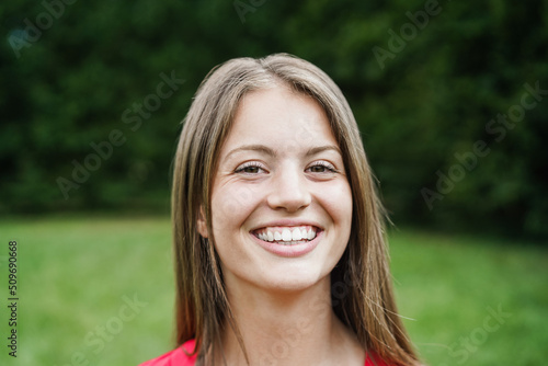 Young happy girl smiling on camera outdoor - Focus on face