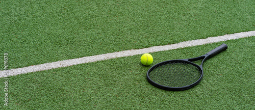 Top view of tennis rackets and ball of green grass. Horizontal sport poster, greeting cards, headers, website © Augustas Cetkauskas