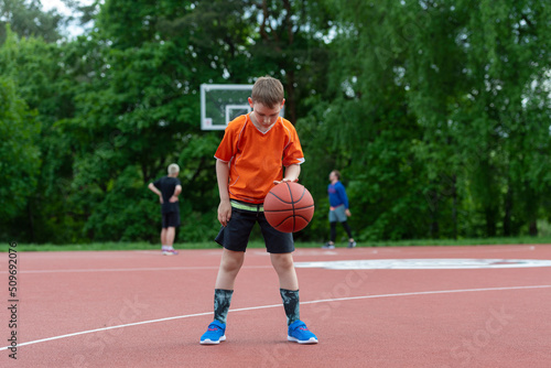 Boy playing basketball on a park court. Concept of a sports lifestyle, training, camp, leisure, vacation. Horizontal sport theme poster, greeting cards, headers, website and app © Augustas Cetkauskas