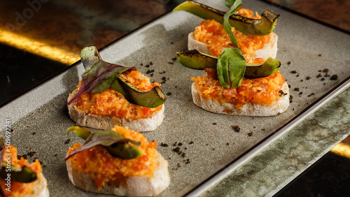 Obraz na płótnie baked bruschetta with salmon, cheese, sun-dried tomatoes and avocado in gray plate on bright background w salonie