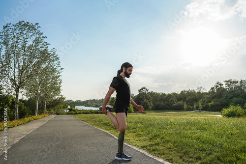 Young fit man with prosthetic leg warming up before workout routine - Focus on right hand