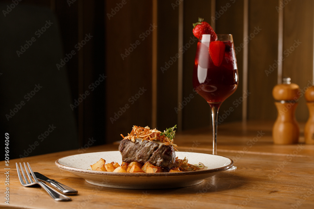 Pastrami sandwich on rye bread served with pickles and mustard sauce. Tasty sandwich with french fries potatoes and Sangria drink on dark background.