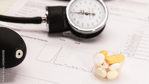 pills and pill, hypertension medication concept, sphygmomanometer and medical exams in the background, treatment of diabetes or cardiovascular problem