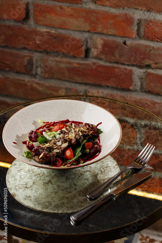 Obraz na płótnie Salad with veal and tomatoes. Beef steak with raw vegetables mix side view. Grilled meat with garnish close-up. Delicious main course on table w salonie