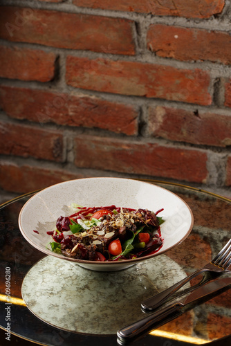 Obraz na płótnie Salad with veal and tomatoes. Beef steak with raw vegetables mix side view. Grilled meat with garnish close-up. Delicious main course on table w salonie
