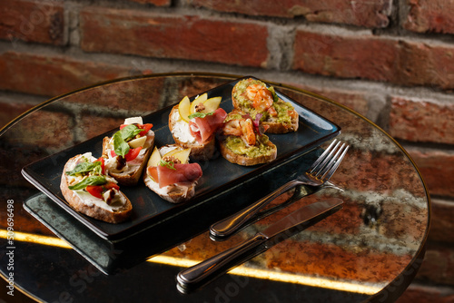 Obraz na płótnie Bruschettas with vegetables. Start dishes with cherry tomatoes, avocado, cream cheese and shrimps. Food composition, tasty italian meal w salonie