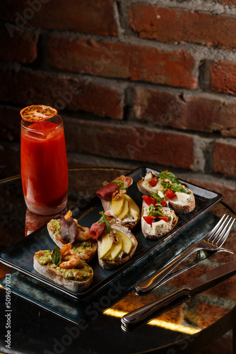Obraz na płótnie Bruschettas with vegetables. Start dishes with cherry tomatoes, avocado, cream cheese and shrimps. Food composition, tasty italian meal w salonie