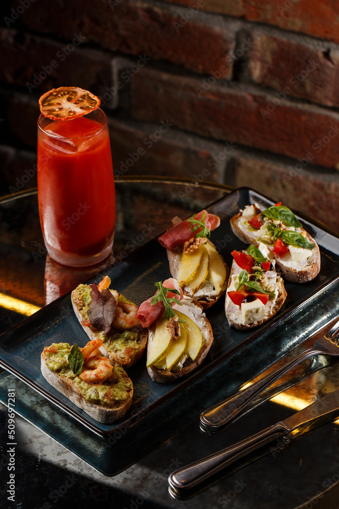 Bruschettas with vegetables. Start dishes with cherry tomatoes, avocado, cream cheese and shrimps. Food composition, tasty italian meal