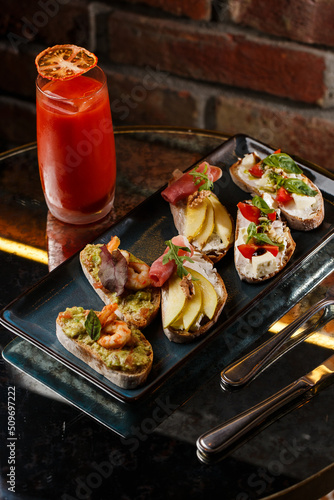 Obraz na płótnie Bruschettas with vegetables. Start dishes with cherry tomatoes, avocado, cream cheese and shrimps. Food composition, tasty italian meal w salonie