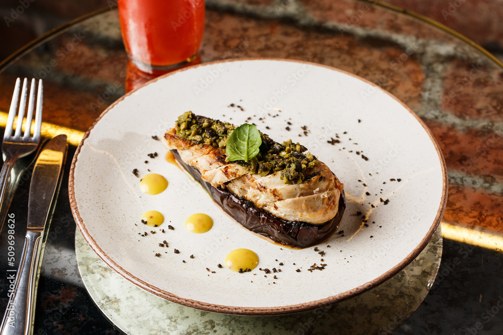 Baked eggplant stuffed with grilled chicken, tomatoes and spices on white plate. Traditional dish Karniyarik of turkish cuisine. View from above
