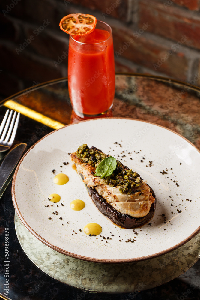 Baked eggplant stuffed with grilled chicken, tomatoes and spices on white plate. Traditional dish Karniyarik of turkish cuisine. View from above