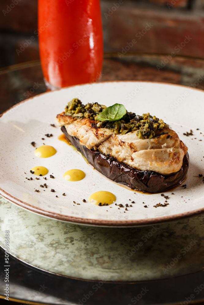 Baked eggplant stuffed with grilled chicken, tomatoes and spices on white plate. Traditional dish Karniyarik of turkish cuisine. View from above