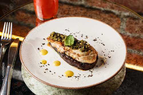 Obraz na płótnie Baked eggplant stuffed with grilled chicken, tomatoes and spices on white plate. Traditional dish Karniyarik of turkish cuisine. View from above w salonie