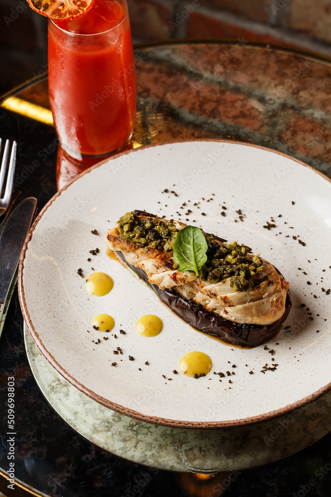Baked eggplant stuffed with grilled chicken, tomatoes and spices on white plate. Traditional dish Karniyarik of turkish cuisine. View from above