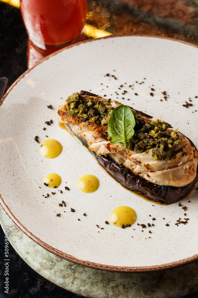 Baked eggplant stuffed with grilled chicken, tomatoes and spices on white plate. Traditional dish Karniyarik of turkish cuisine. View from above