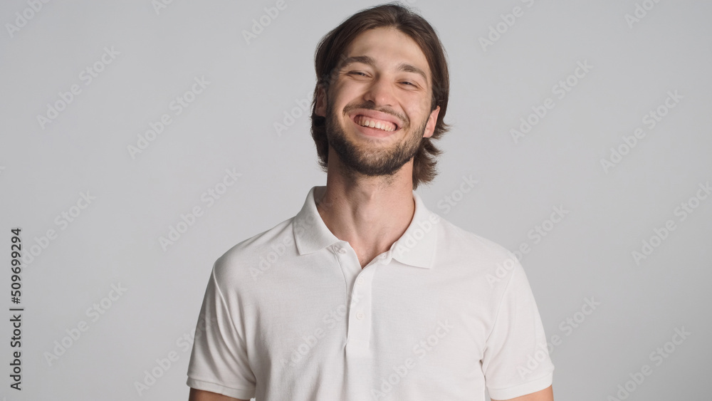 Successful bearded man looking happy smiling at camera against a gray background. Cheerful male model posing in studio. Happy face Successful bearded man looking happy smiling at camera against a gray background. Cheerful male model posing in studio. Happy face