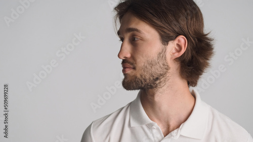 Side view of bearded man looking on space for advertisement or promotion isolated on white background. Attractive guy standing near copy space