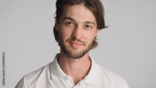 Confident bearded man looking good posing at camera over white background. Attractive sensual guy standing